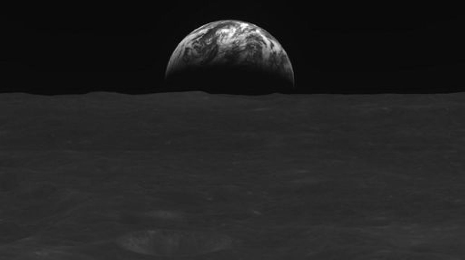 This handout image taken on December 31, 2022 and provided by the Korea Aerospace Research Institute (KARI) on January 3, 2023 shows a black-and-white image of the lunar surface and Earth taken by South Korean lunar orbiter Danuri after reaching the moon'