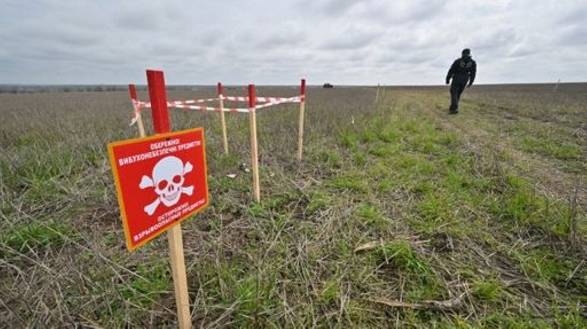 Un démineur de HALO Trust passe devant un champ de mines lors de travaux de déminage d'une ferme près du village de Yevgenivka, dans la région de Mykolaiv, le 9 avril 2023, lors de l'invasion russe de l'Ukraine. 