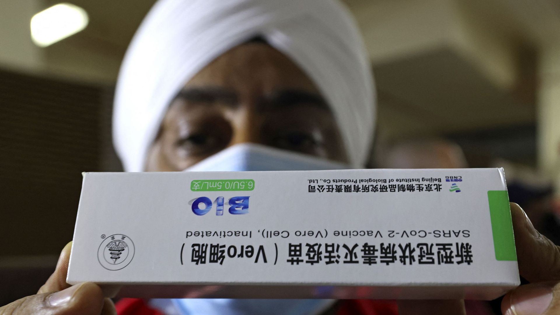 La diplomatie du vaccin. L'affaire des Chinois, des Russes et des Indiens. Un travailleur de la santé sikh détient une boîte du vaccin chinois Sinopharm COVID-19 lors de la vaccination au Guru Nanak Darbar Gurudwara (temple sikh) à Dubaï le 28 février 202