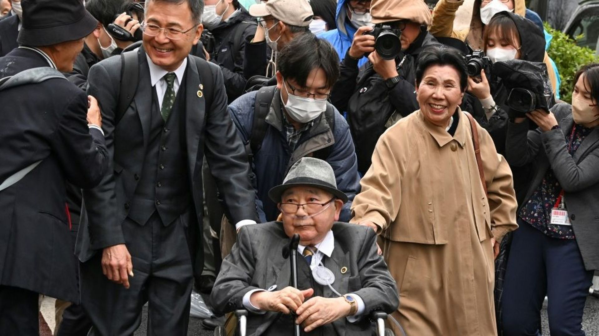Iwao Hakamada (c), le plus vieux condamné à mort du monde entouré de ses proches et de sa sœur Hideko, devant le tribunal à Tokyo le 13 mars 2023