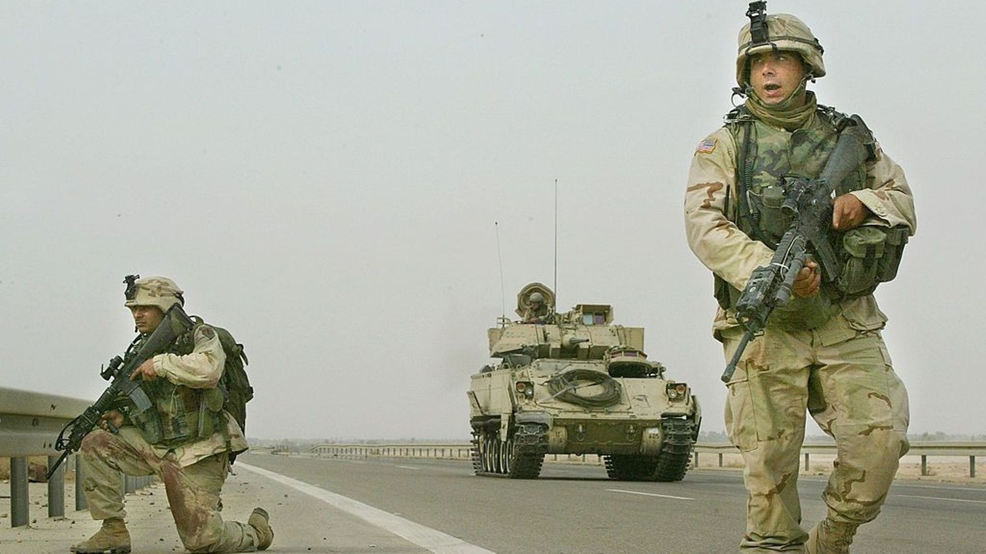 Les soldats de l'armée de la 82e division d'infanterie aéroportée ripostent aux coups de feu lors d'une patrouille avec un véhicule de combat M2 Bradley, le 8 novembre 2003 à Fallujah, en Irak.