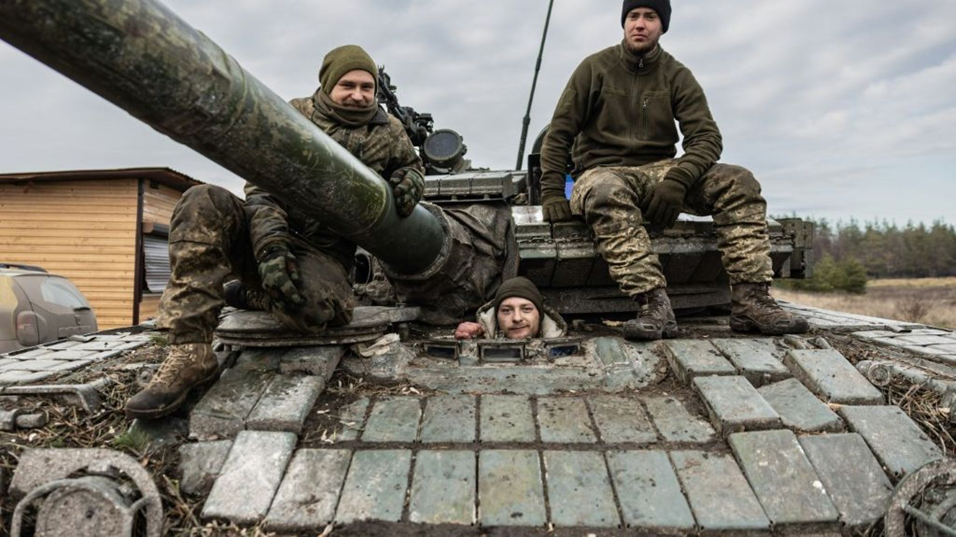 Deux soldats ukrainiens posent sur un tank T-80, dans un lieu non précisé de l’est de l’Ukraine, le 29 décembre 2022