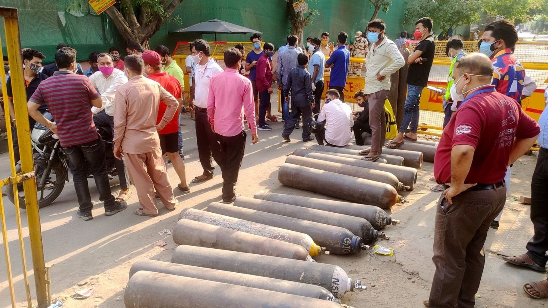 Devant l’usine Vaibhav, au sud-est de New Delhi, la police a restreint l’accès à l’usine. Des dizaines de personnes attendent de pouvoir remplir leur bouteille d’oxygène
