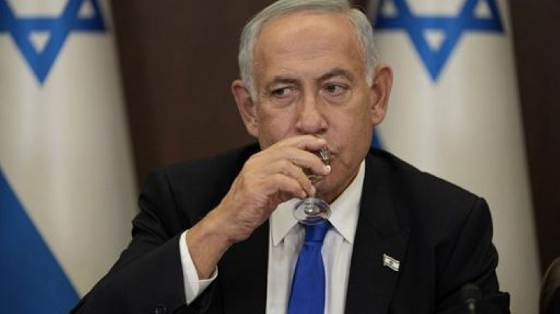 Newly sworn-in Israeli Prime Minister Benjamin Netanyahu toasts with a drink during the first cabinet meeting of his new government in Jerusalem, on December 29, 2022. Netanyahu was sworn in as prime minister after a stint in opposition, heading what anal