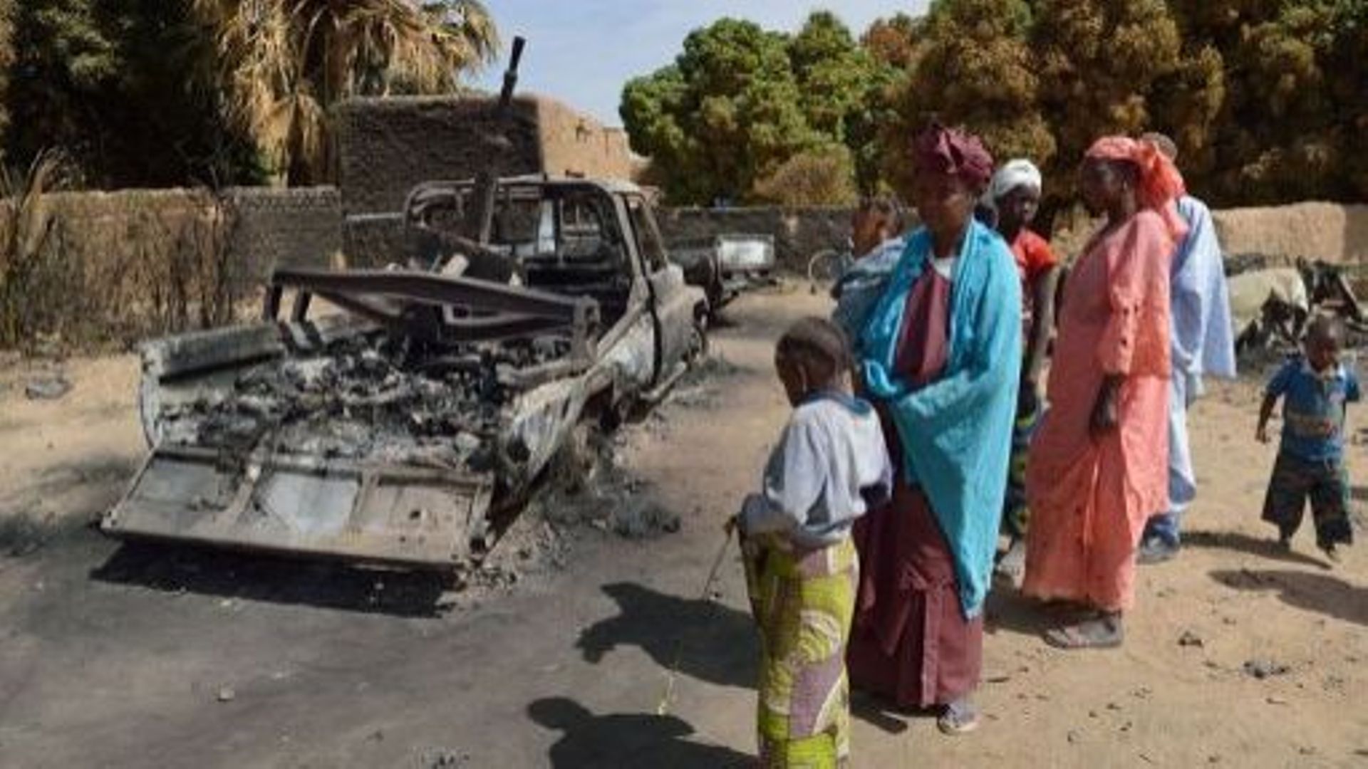 Des Maliennes le 23 janvier 2013 à Diabali devant un véhicule des groupes islamistes armés détruits par des tirs français