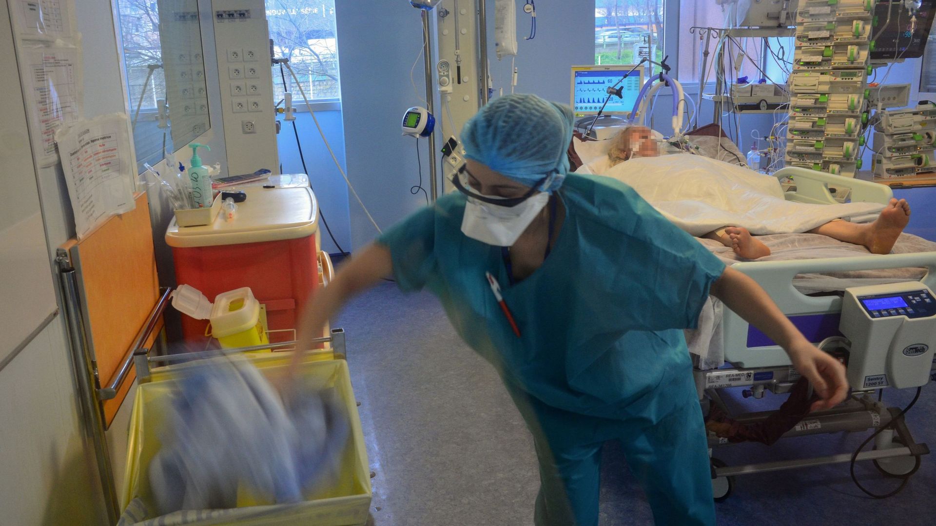 Une infirmière met ses vêtements de protection dans une poubelle après avoir soigné un patient infecté COVID-19 et confiné aux soins intensifs de l’hôpital Bichat à Paris – 13 mars 2020.