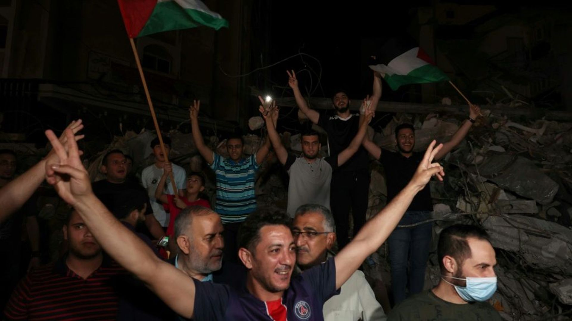 Un homme fait le V de la victoire pour célébrer le cessez-le-feu entre Israël et le Hamas, le 20 mai 2021 à Gaza