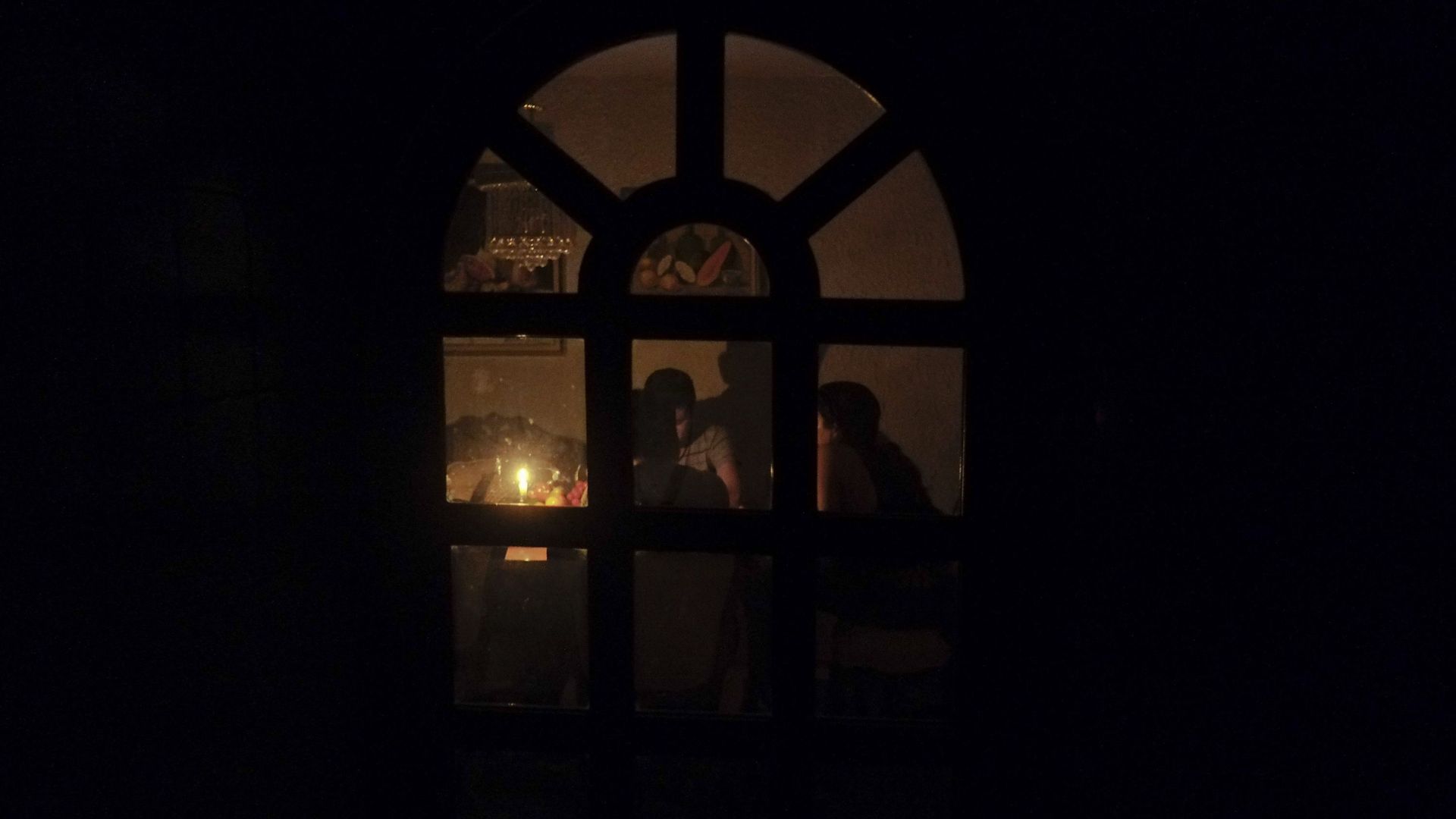 Une famille s'éclaire à la bougie suite à la décision du président Maduro de couper l'électricité quatre heures par jour dans les dix états les plus peuplés du Venezuela.