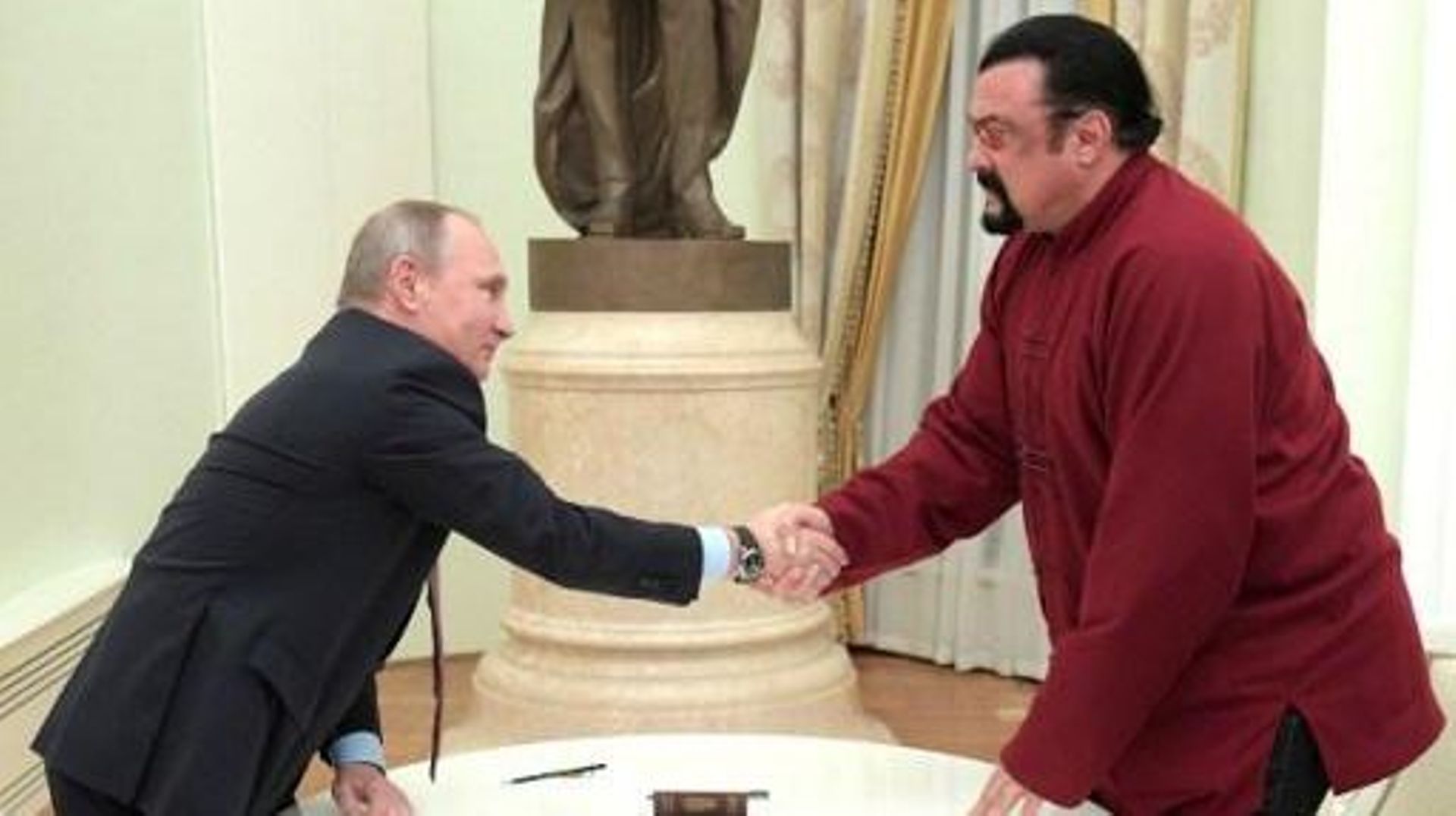 Russian President Vladimir Putin (L) shakes hands with US action hero actor Steven Seagal after presenting a Russian passport to him during a meeting at the Kremlin in Moscow on November 25, 2016.
Alexey DRUZHININ / SPUTNIK / AFP