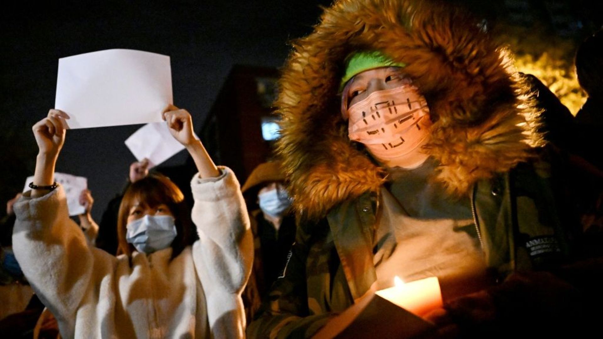 Des manifestants brandissent des feuilles de papier A4 blanches lors d’un rassemblement contre la politique "zéro Covid" du gouvernement chinois, le 28 novembre 2022 à Pékin