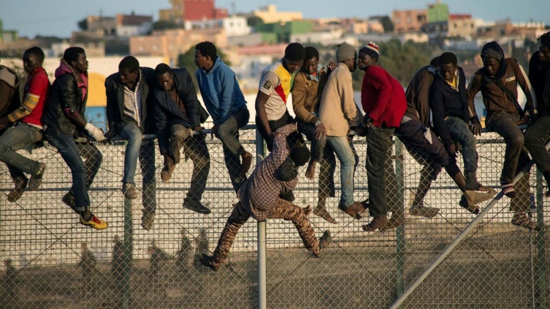 Des migrants escaladent la clôture marquant la frontière entre l'enclave espagnole de Melilla et le Maroc en octobre 2014