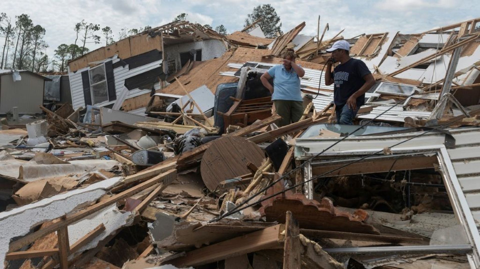 Des habitants de Lake Charles dans les débris de leur mobile home détruit par le passage de l'ouragan Laura, le 27 août 2020 en Louisiane