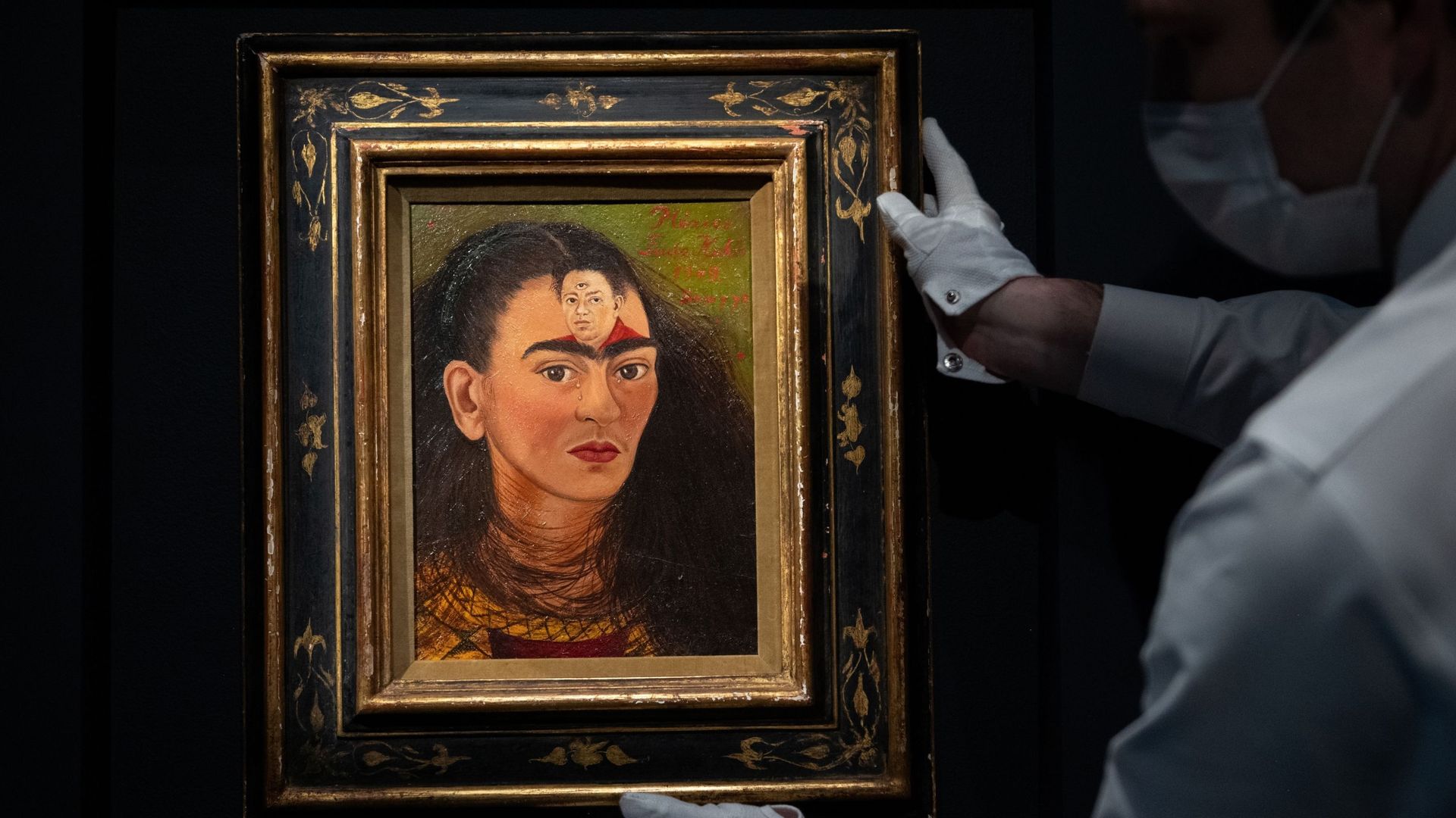 Un manutentionnaire tient le dernier autoportrait de Frida Kahlo "Diego y yo" lors de l’avant-première de presse de la Collection Macklowe chez Sotheby’s le 5 novembre 2021 à New York.