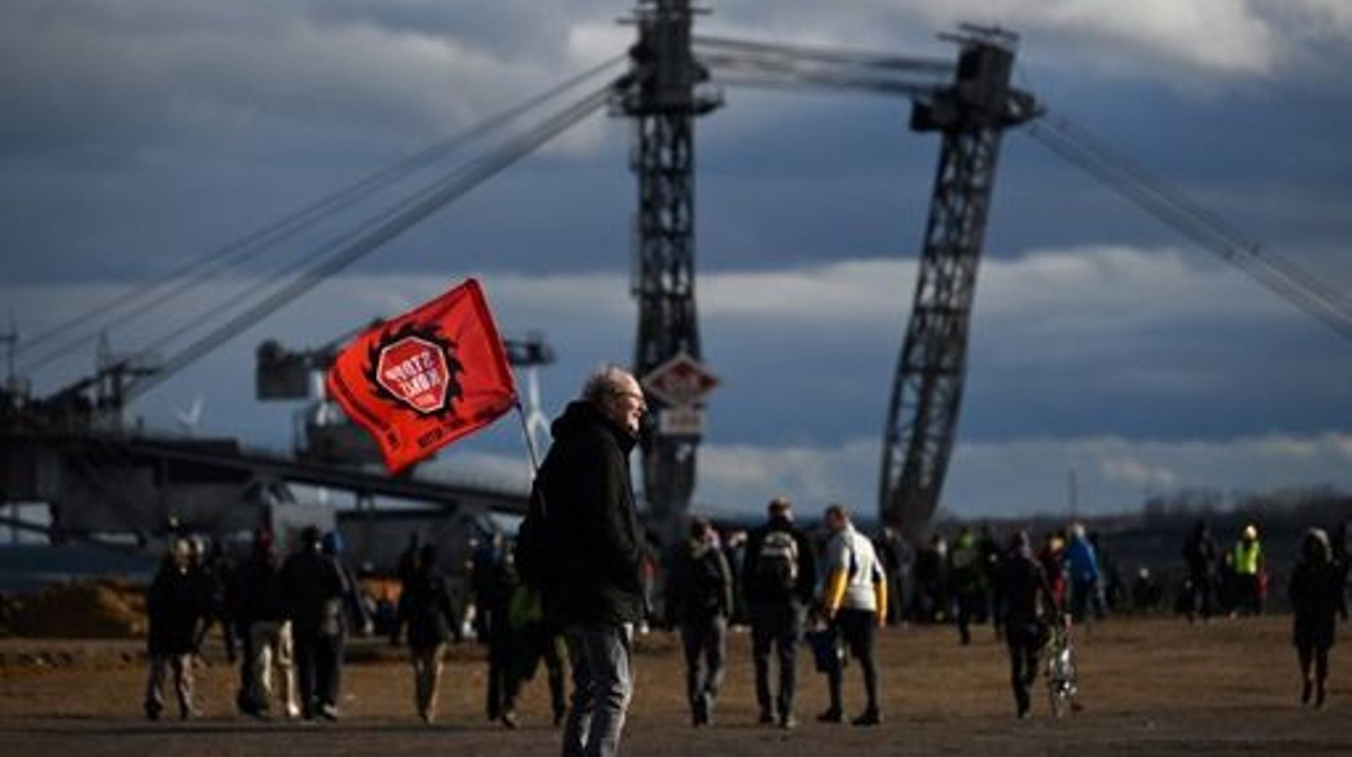 An activist stands with a flag at the Garzweiler lignite open cast mine ahead of the imminent clearance of the nearby village of Luetzerath, western Germany on January 8, 2023. Police prepare the planned evacuation of the village occupied by activists, w