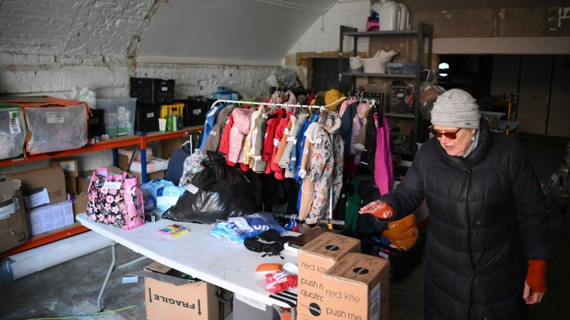 Une bénévole au milieu de cartons de vêtements et de jouets pour enfants, dans une banque de dons du quartier de Hackney, le 23 janvier 2023 à Londres.