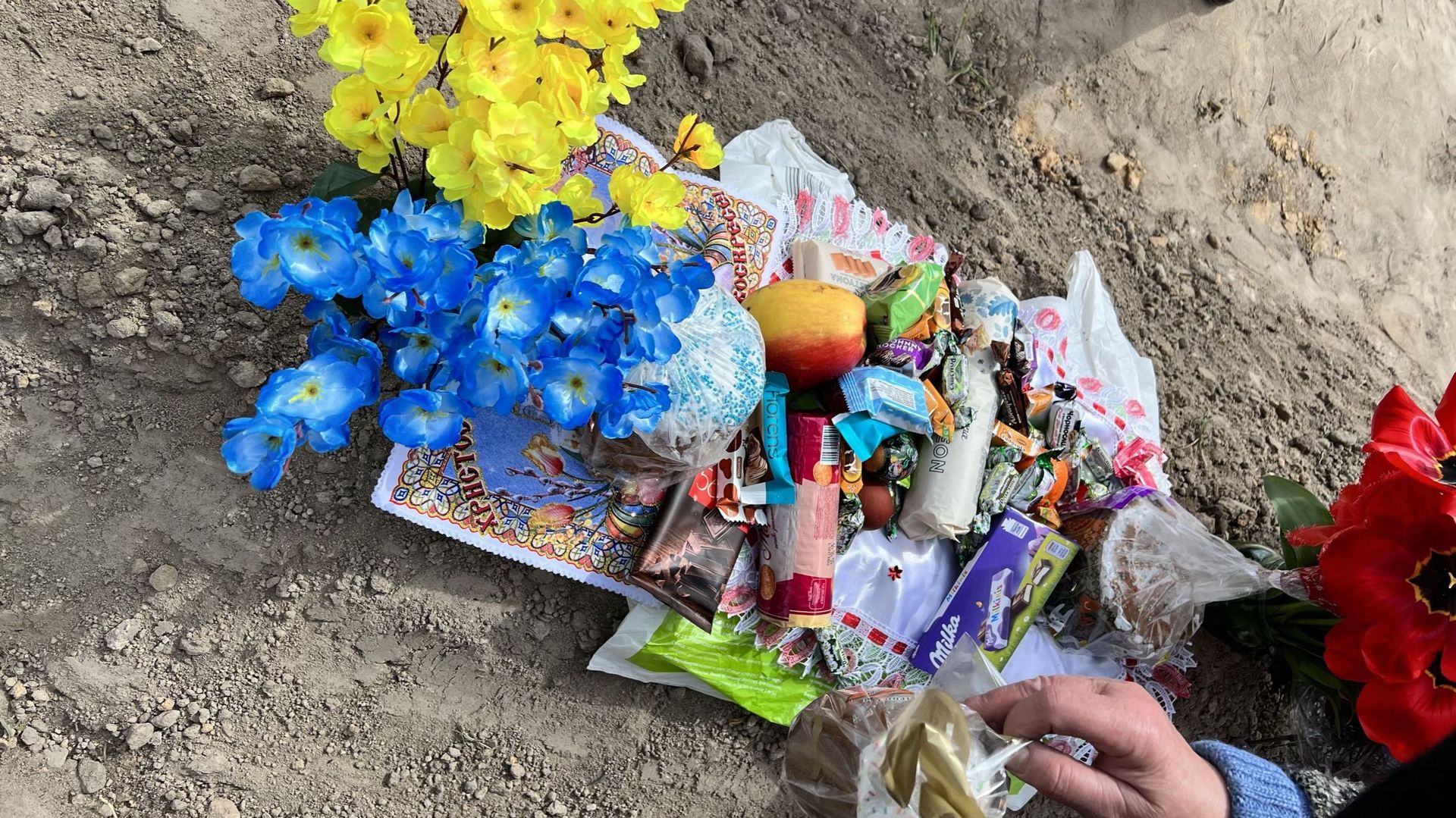 La tombe d’André Kuyavets est recouverte de fleurs aux couleurs de l’Ukraine et de chocolats.