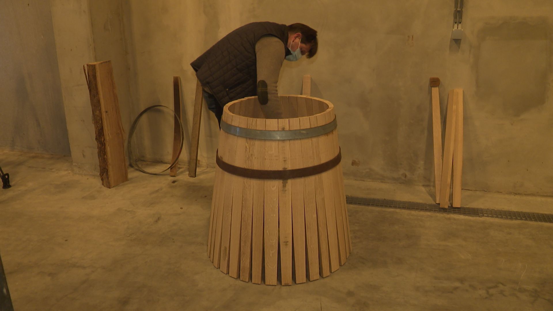 Assemblage d’une trentaine de douelles pour la fabrication d’un tonneau en bois de chêne wallon