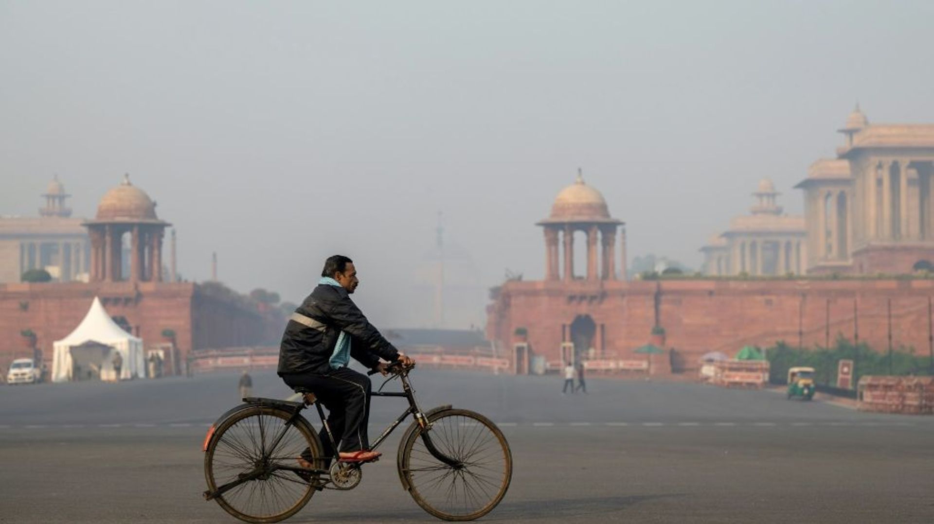 Un homme sur son vélo devant le Palais présidentiel à New Delhi, le 19 novembre 2021