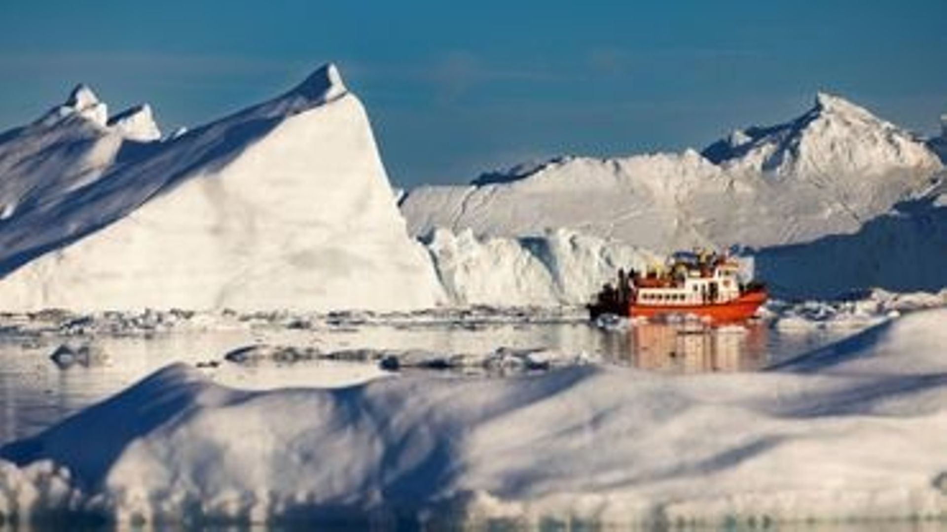Un bateau de touristes navigue au milieu des icebergs dans la baie de Disko, le 1er juillet 2022 à Ilulissat, au Groenland .