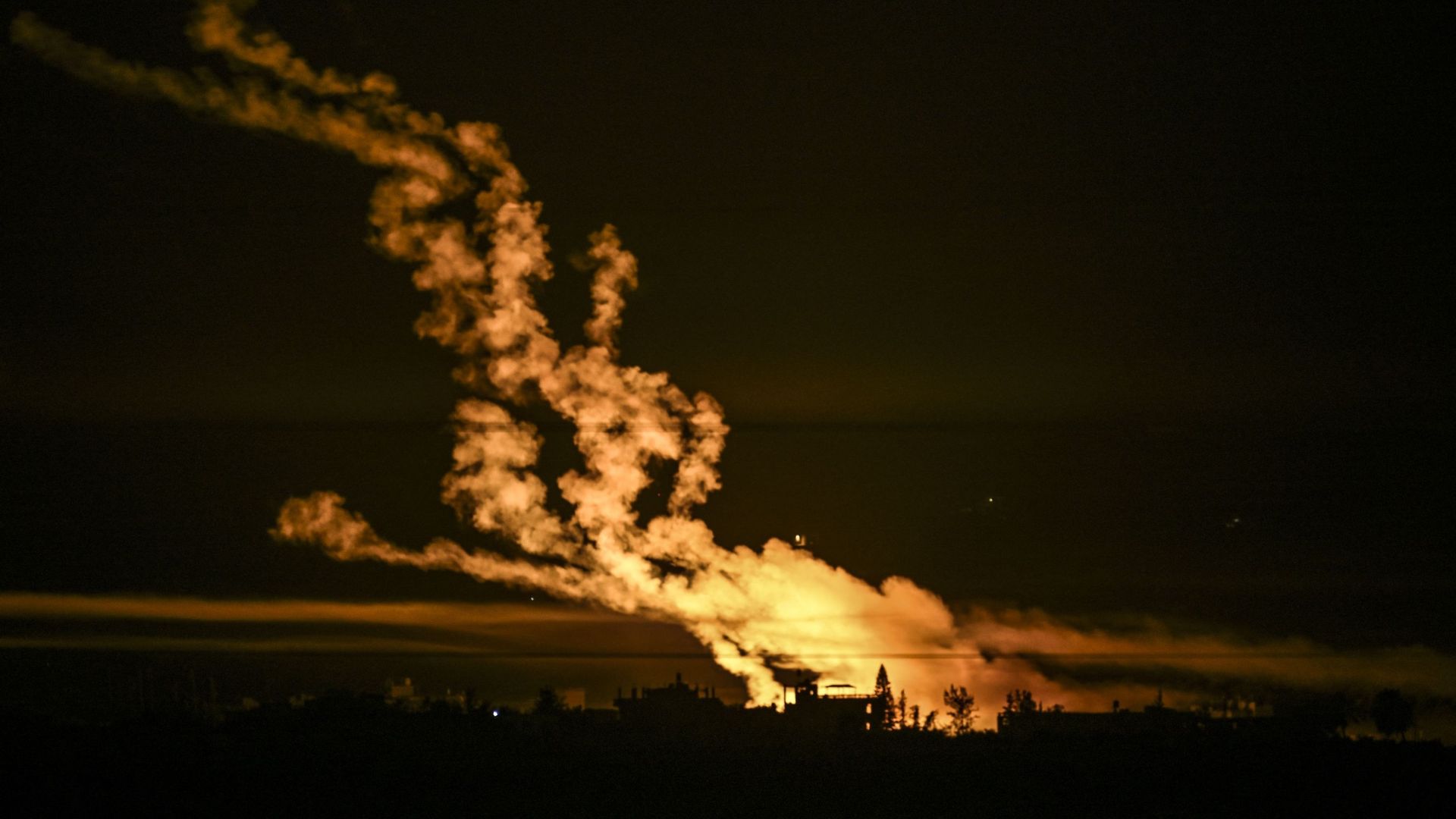 Cette photo prise depuis une position près de Sderot, le long de la frontière israélienne avec la bande de Gaza, le 31 octobre 2023, montre des fusées éclairantes larguées par les forces israéliennes au-dessus de l'enclave palestinienne au milieu des comb