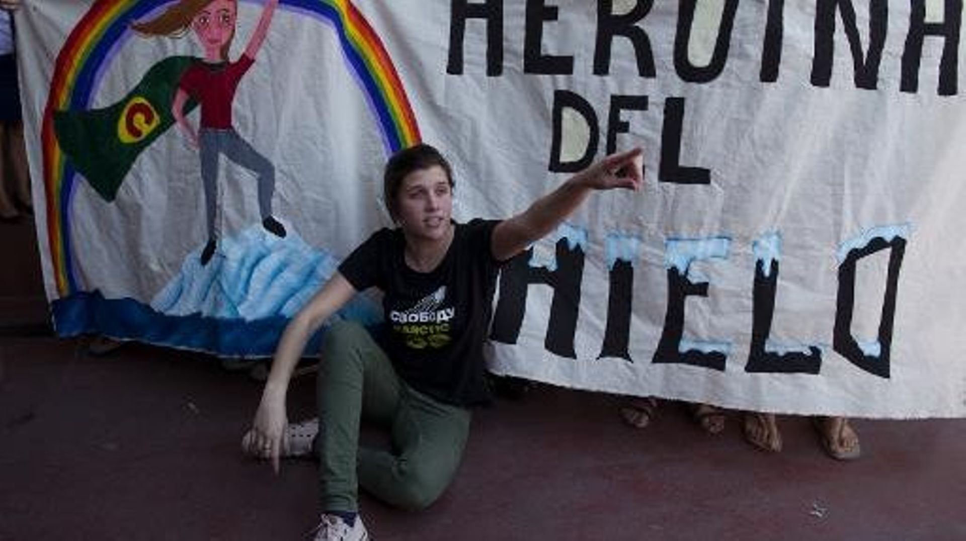 La militante argentine de Greenpeace Camila Speziale devant une banderole la célébrant comme une "héroïne de la glace", le 28 décembre à l'aéroport de Buenos Aires