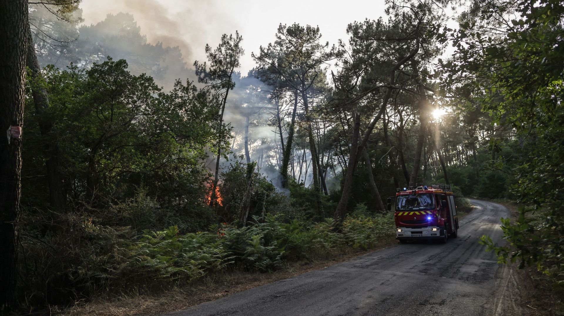 Un camion de pompiers traverse un feu de forêt au pied de la dune du Pilat près de La Teste-de-Buch, dans le sud-ouest de la France, le 13 juillet 2022. – Un incendie en cours depuis l’après-midi du 12 juillet 2022 a brûlé 1500 hectares de pinède près de