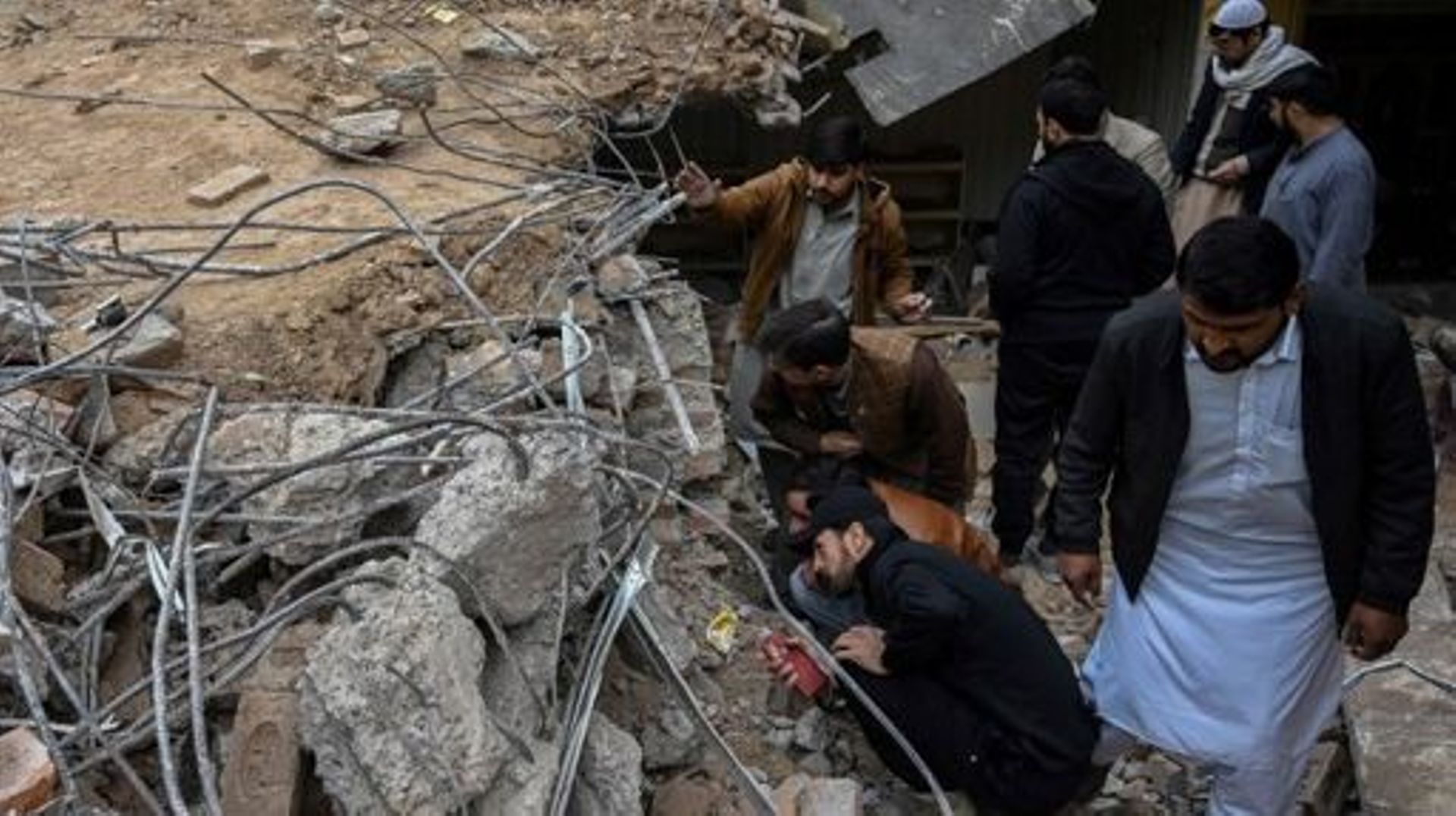 Plain-clothed policemen inspect the site as they gather over the rubble of a damaged mosque following January's 30 suicide blast inside the police headquarters in Peshawar on February 1, 2023.  A suicide blast at a mosque inside a Pakistan police headquar