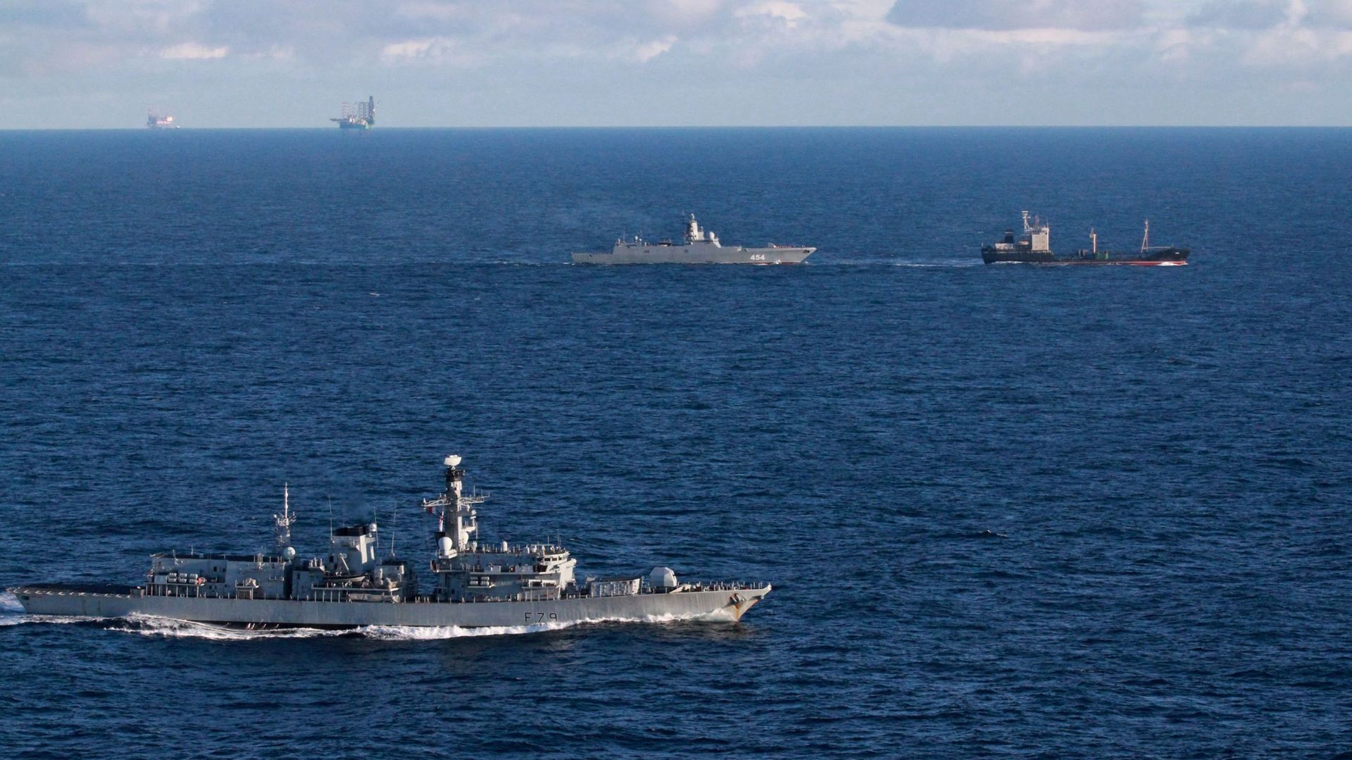 La frégate britannique de type 23 de la Royal Navy, le HMS Portland (à gauche), suit la frégate russe du projet 22350, l'Admiral Gorshkov (à droite), et le cargo Kama, alors qu'ils naviguent dans les eaux internationales de la mer du Nord, près du Royaume