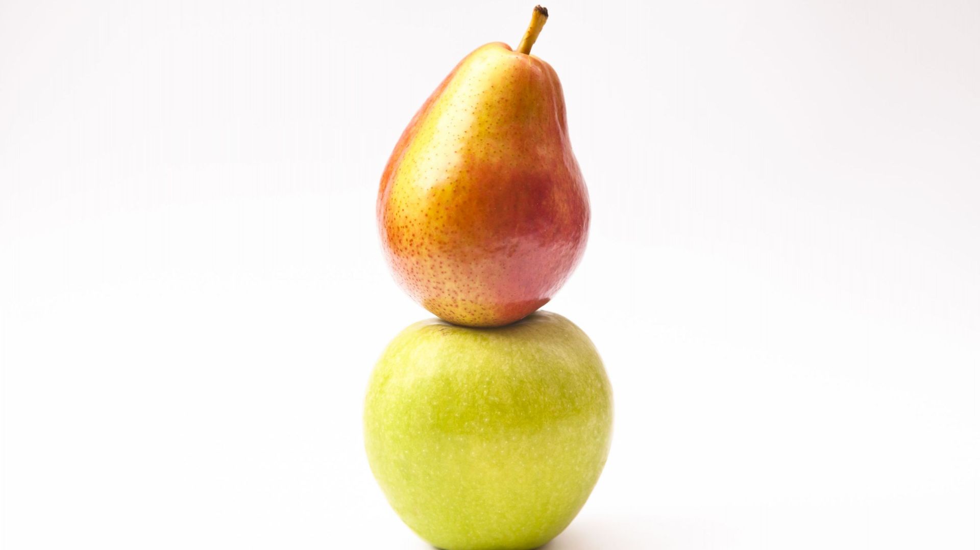 A pear balancing on an apple