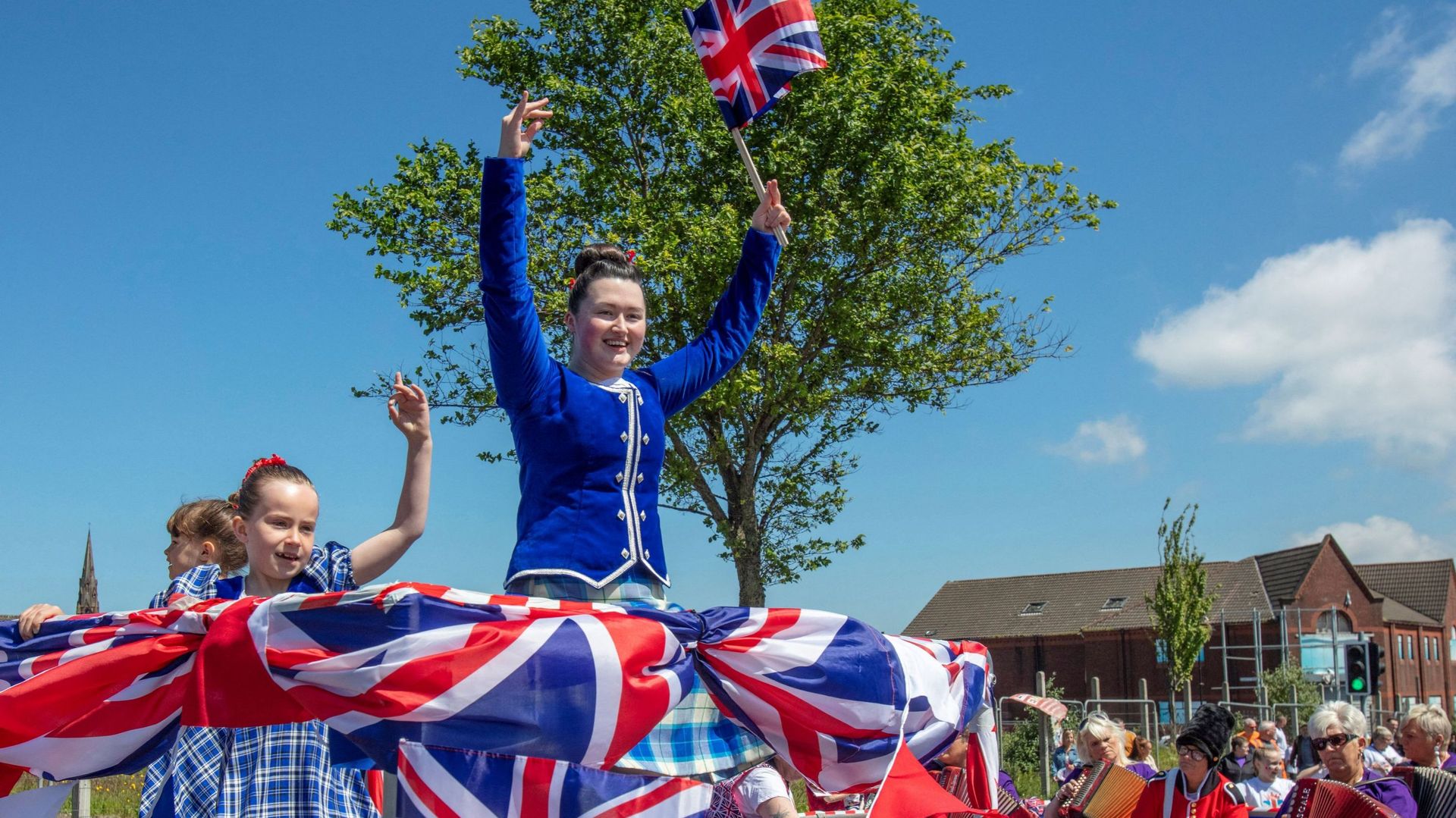 Image d'illustration - Une jeune femme tient un drapeau national britannique alors qu'elle participe à un défilé lors d'une fête de rue à Shankill, à Belfast en Irlande du Nord, le 4 juin 2022.