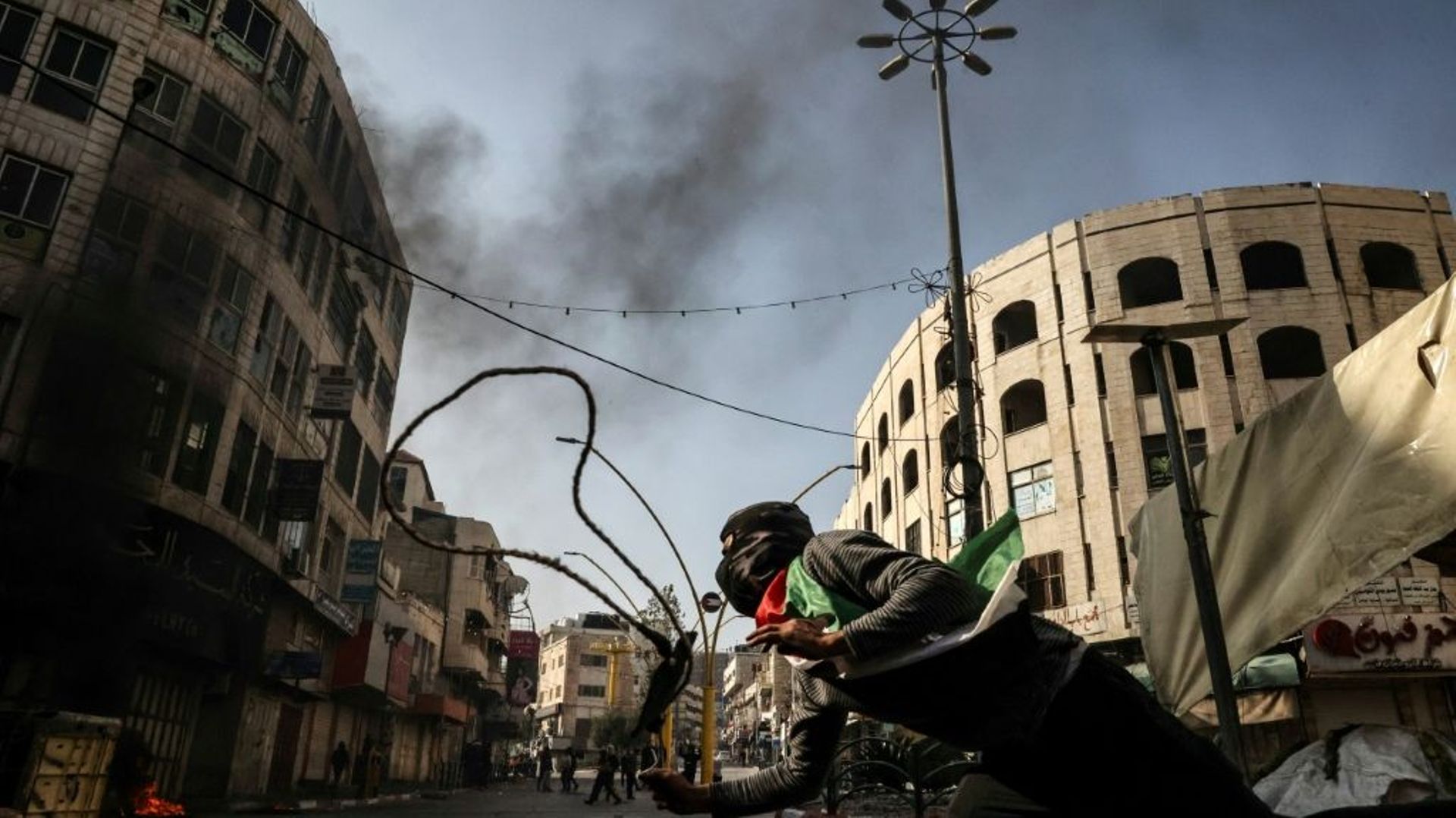 Un manifestant palestinien utilise un lance-pierres contre les forces israéliennes à Hébron en Cisjordanie, le 18 février 2022.
