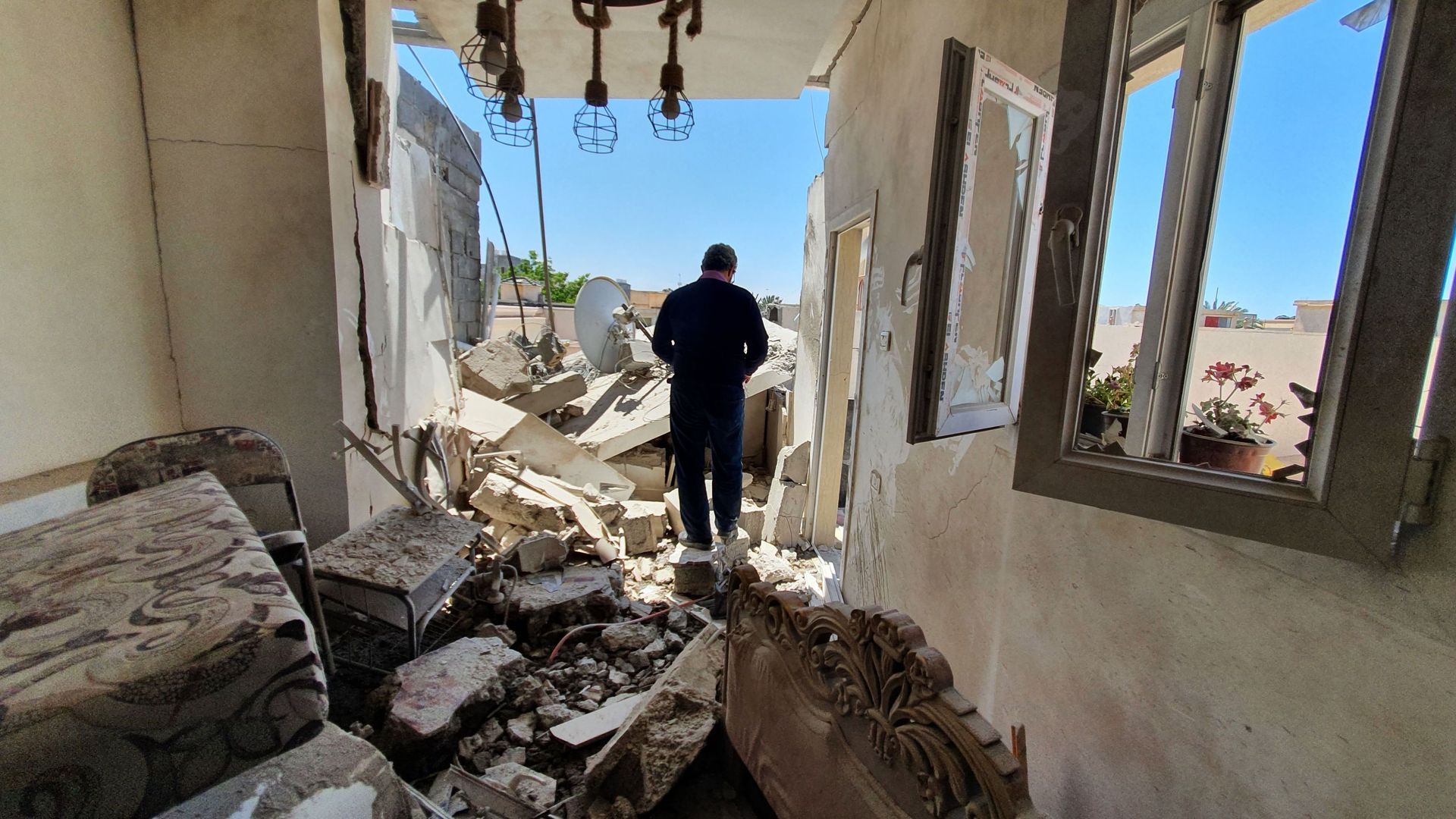 Un habitant se promène dans les décombres d’un bâtiment endommagé à cause d’un bombardement des forces de Khalifa Haftar dans un quartier résidentiel de Tripoli, détenu par le gouvernement d’accord national (GNA) reconnu par les Nations unies, le 1er mai 