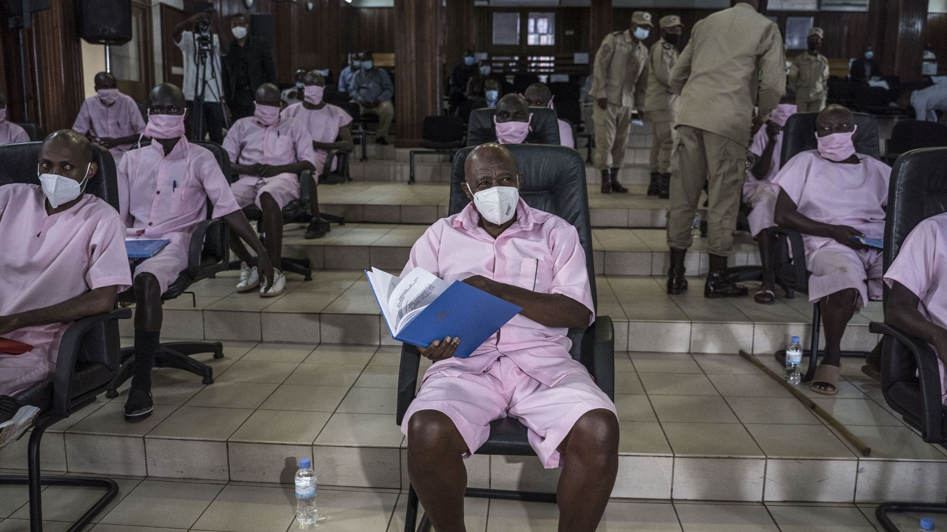 En tenue rose de prisonnier, Paul Rusesabagina a comparu avec ses coaccusés pour la première journée de son procès, le 17 février.