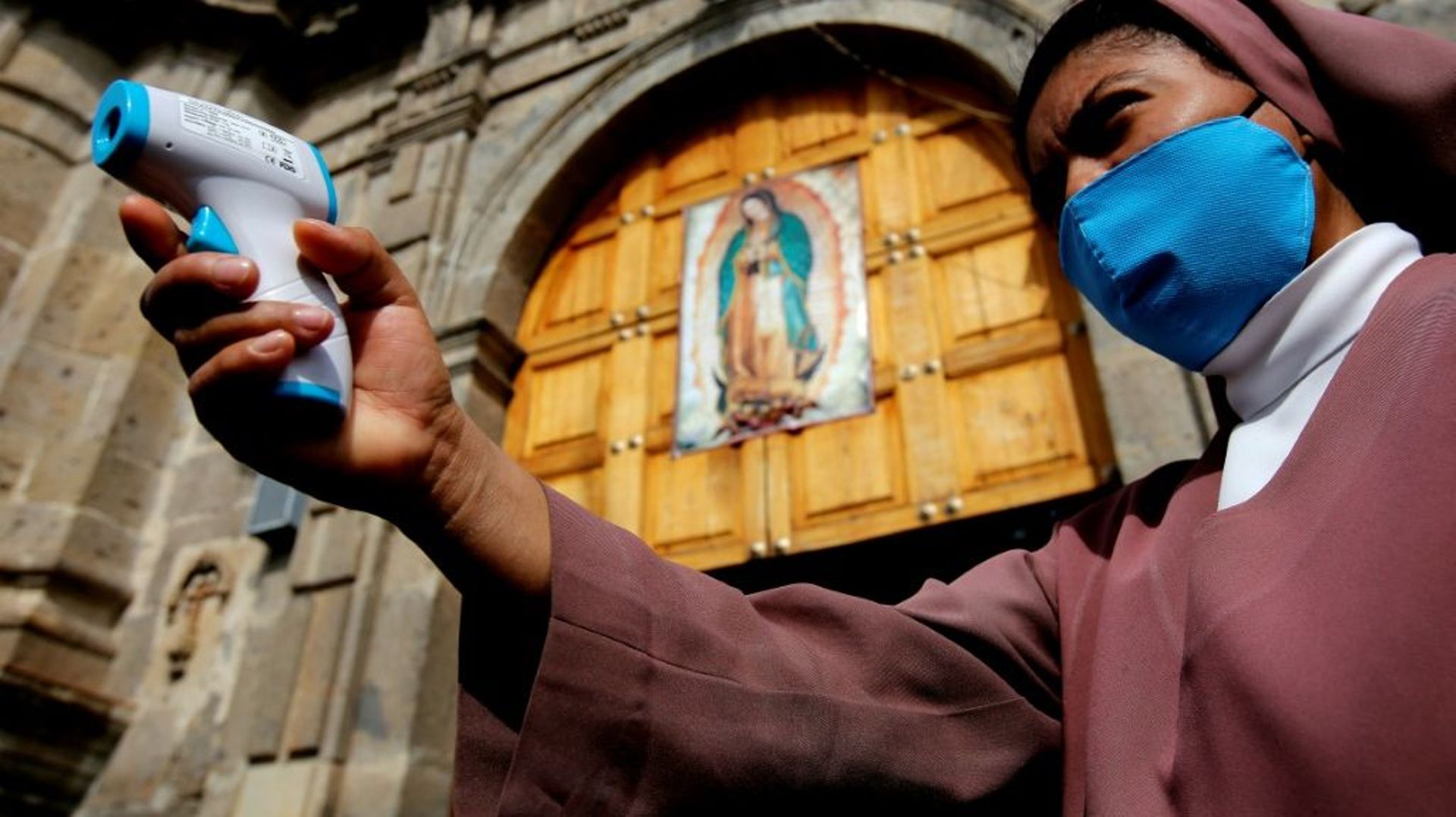 Une religieuse vérifie la température des fidèles, lors de la procession à Guadalajara, le 12 décembre 2020