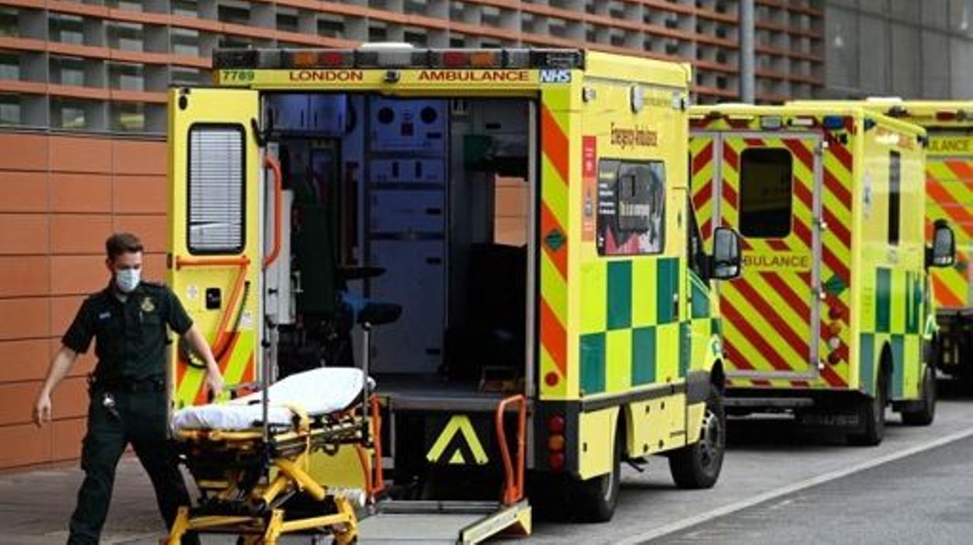 A paramedic wheels a stretcher off an ambulance outside the Royal London Hospital in east London on November 12, 2021.  All frontline workers in the National Health Service (NHS) in England will need to be fully vaccinated against Covid-19 from April 1 or