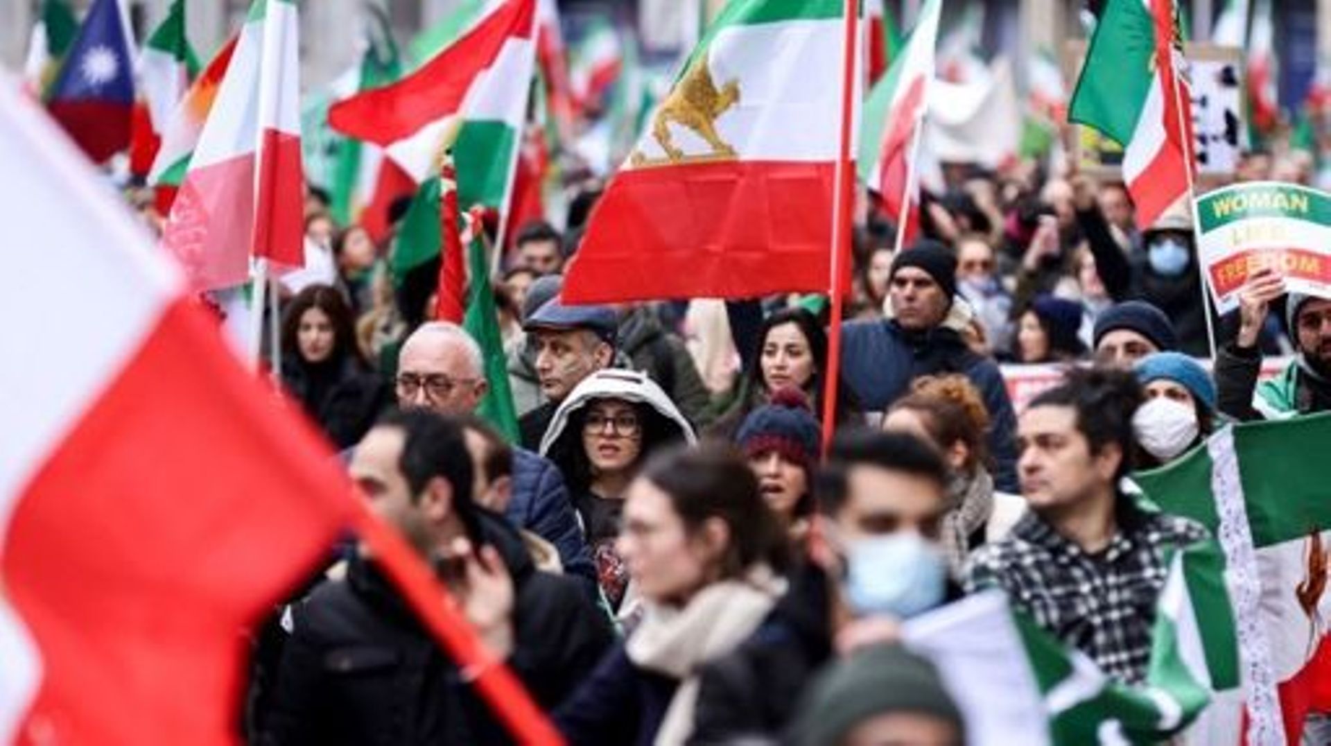 Demonstrators hold the pre-Islamic 1979 Revolution flag as they takes part during a protest supporting Iranian resistance movement in Brussels on February 20, 2023. Kenzo TRIBOUILLARD / AFP