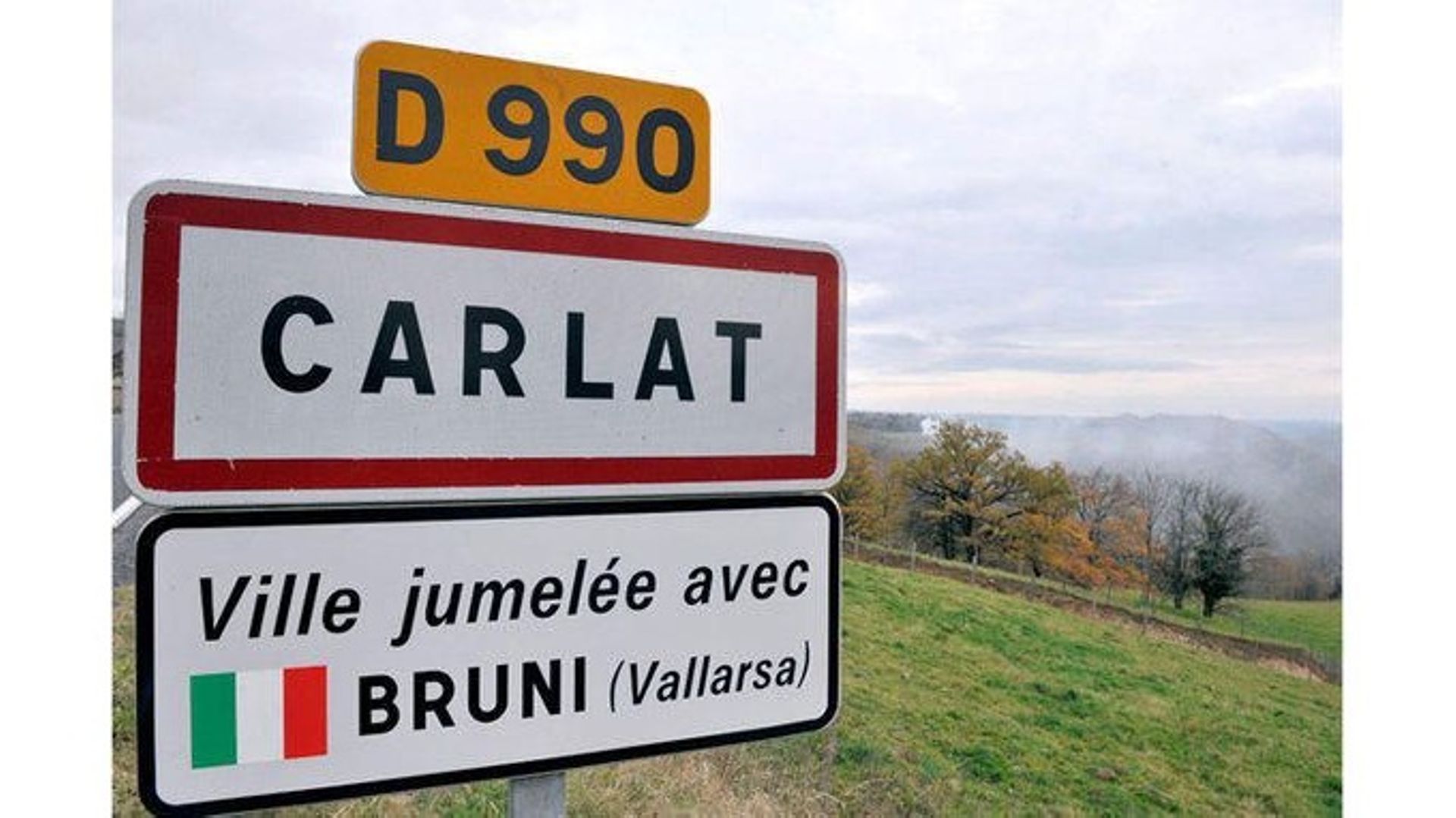 Panneau d’entrée dans la localité de Carlat en France jumelé avec Bruni en Italie