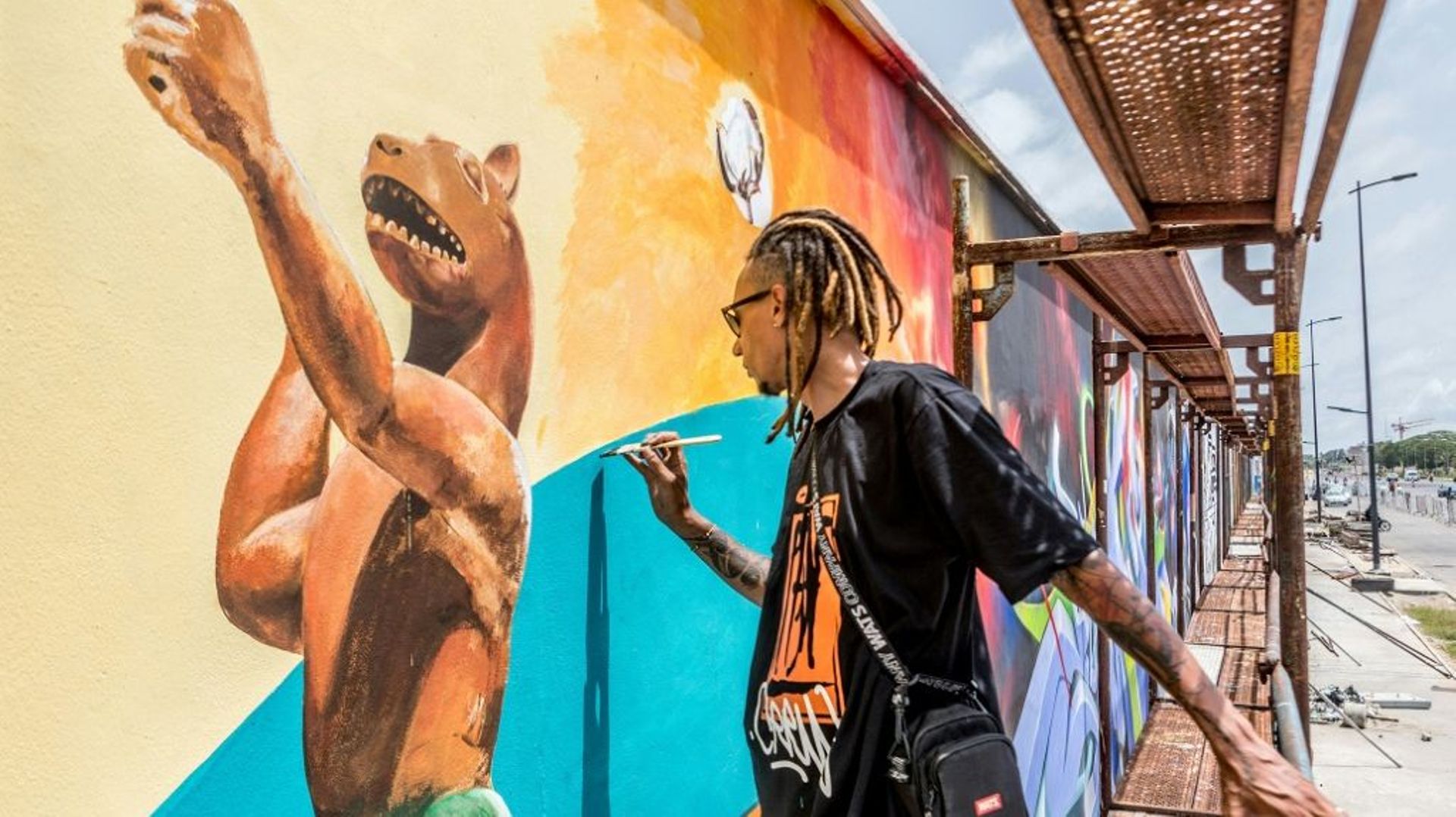 L’artiste brésilien Edgar Bernardo Dos Santos (Ed-Mun) réalise une fresque murale, pendant le festival Effet Graff, le 18 mai 2022 à Cotonou, au Bénin.