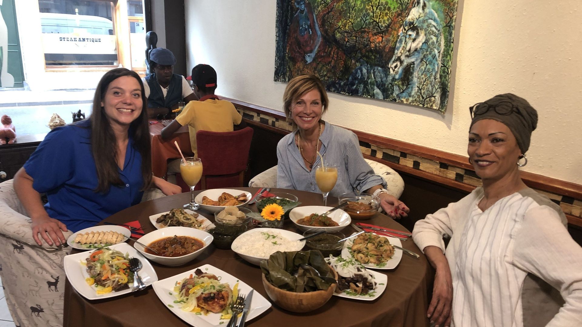 Armelle entourée par Niki Compagnino, Zinneguide (à gauche) et par Monique Fodderie, propriétaire du restaurant Inzia dans le quartier de Matonge.