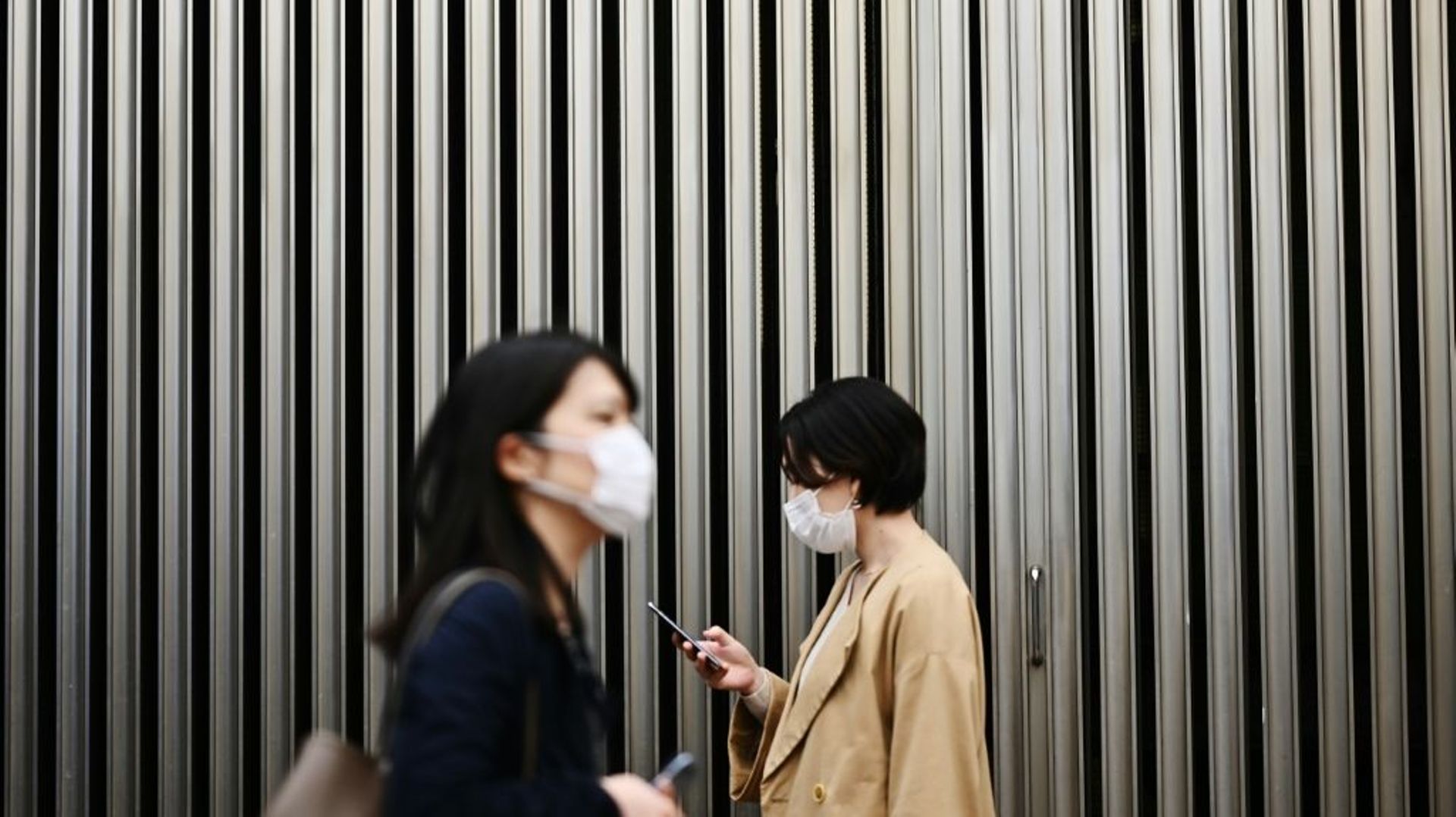 Deux femmes portent un masque de protection pendant l'épidémie de coronavirus, le 18 mars 2020 à Tokyo, au Japon