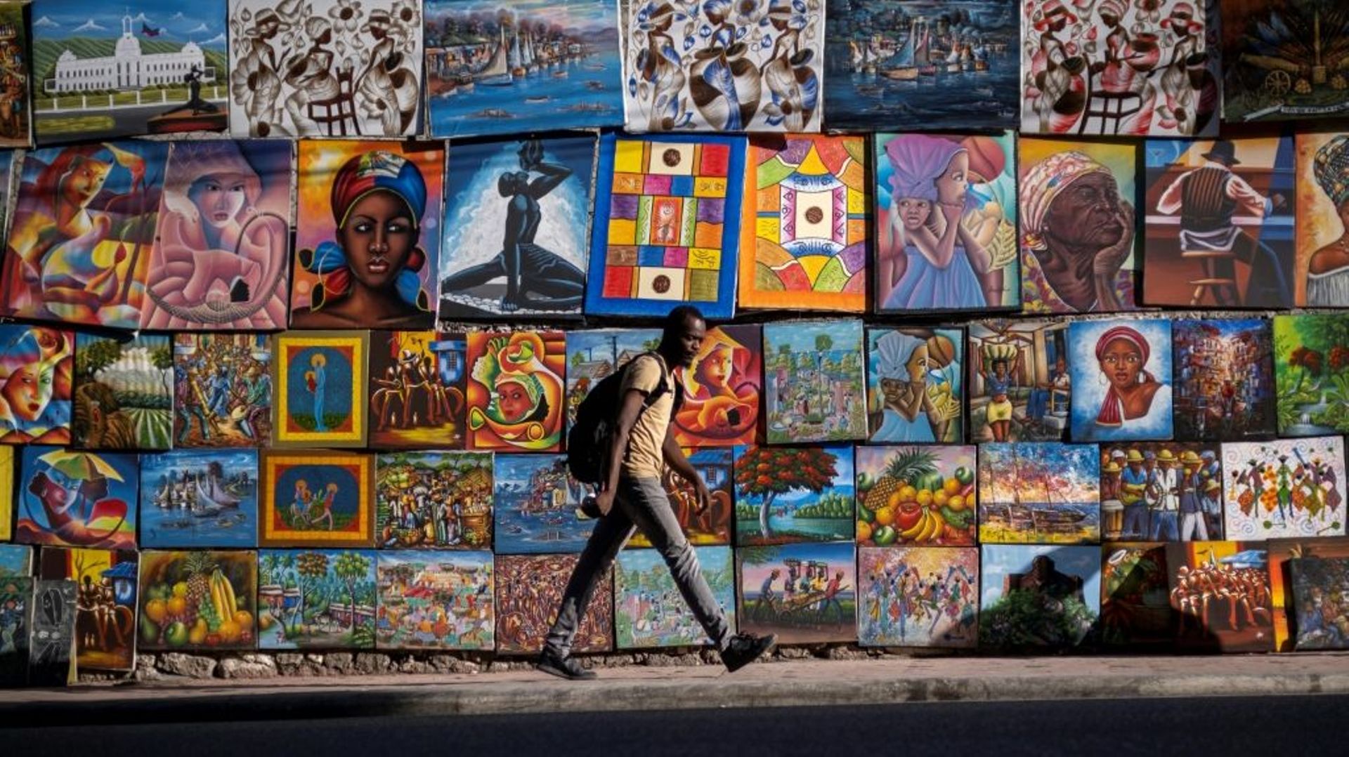 Un homme marche sur le trottoir d'une rue déserte à Port-au-Prince le 27 octobre 2021, lors du troisième jour de grève générale contre la pénurie de carburants causée par les gangs
