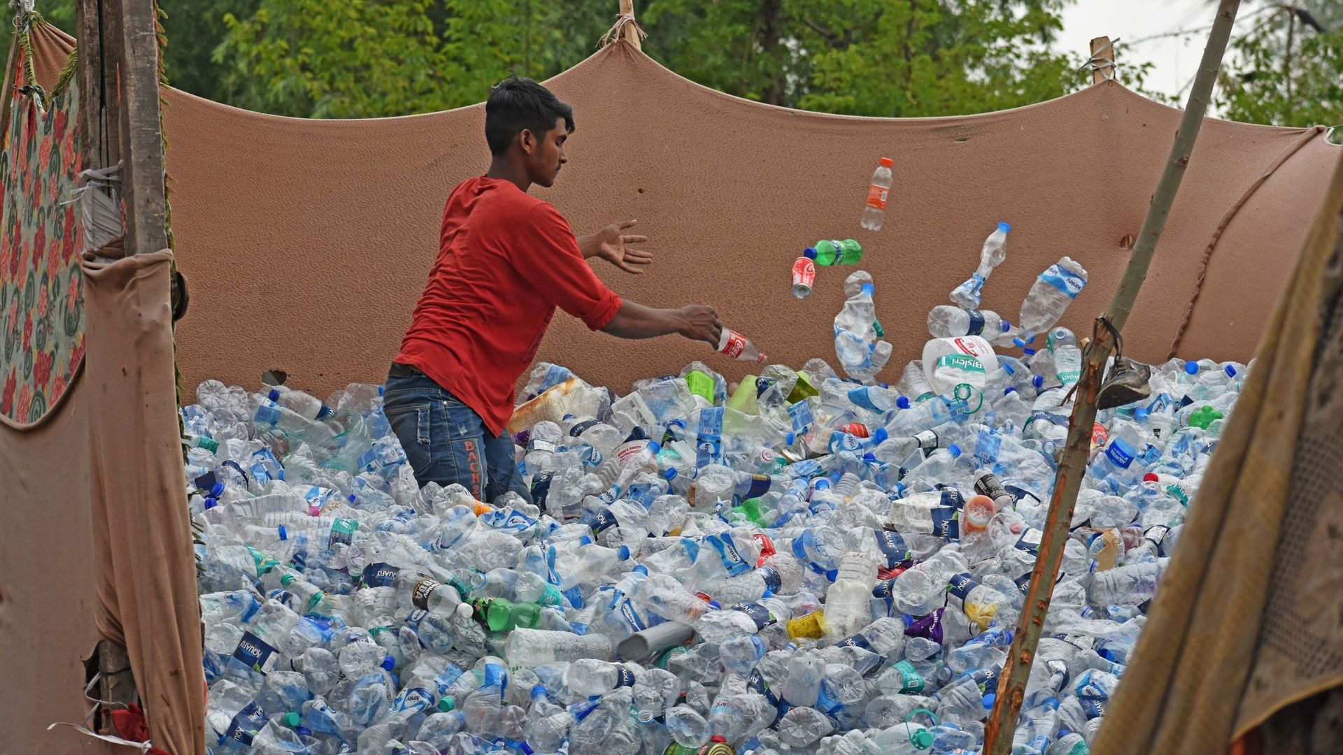 Un collecteur de déchets trie des bouteilles en PET (polyéthylène téréphtalate) dans une zone de stockage en plein air pour les déchets plastiques lors de la Journée mondiale de l'environnement à Srinagar, au Cachemire, le 5 juin 2023. 