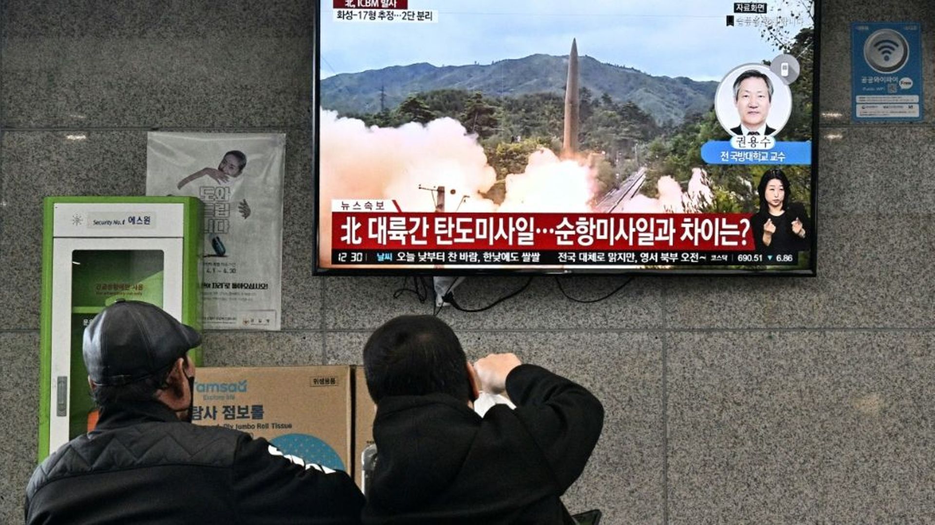 Des personnes regardent un écran de télévision montrant des images d'un missile tiré par la Corée du Nord, le 3 novembre 2022, à Ulleungdo (Corée du Sud)
