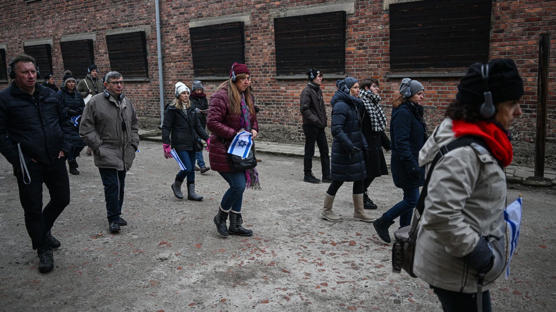 Des membres du syndicat des enseignants israéliens arrivent pour déposer des couronnes en hommage aux victimes du régime nazi près du mur de la mort lors de la journée de commémoration de l’Holocauste sur l’ancien site d’Auschwitz I, le 27 janvier 2023 à 