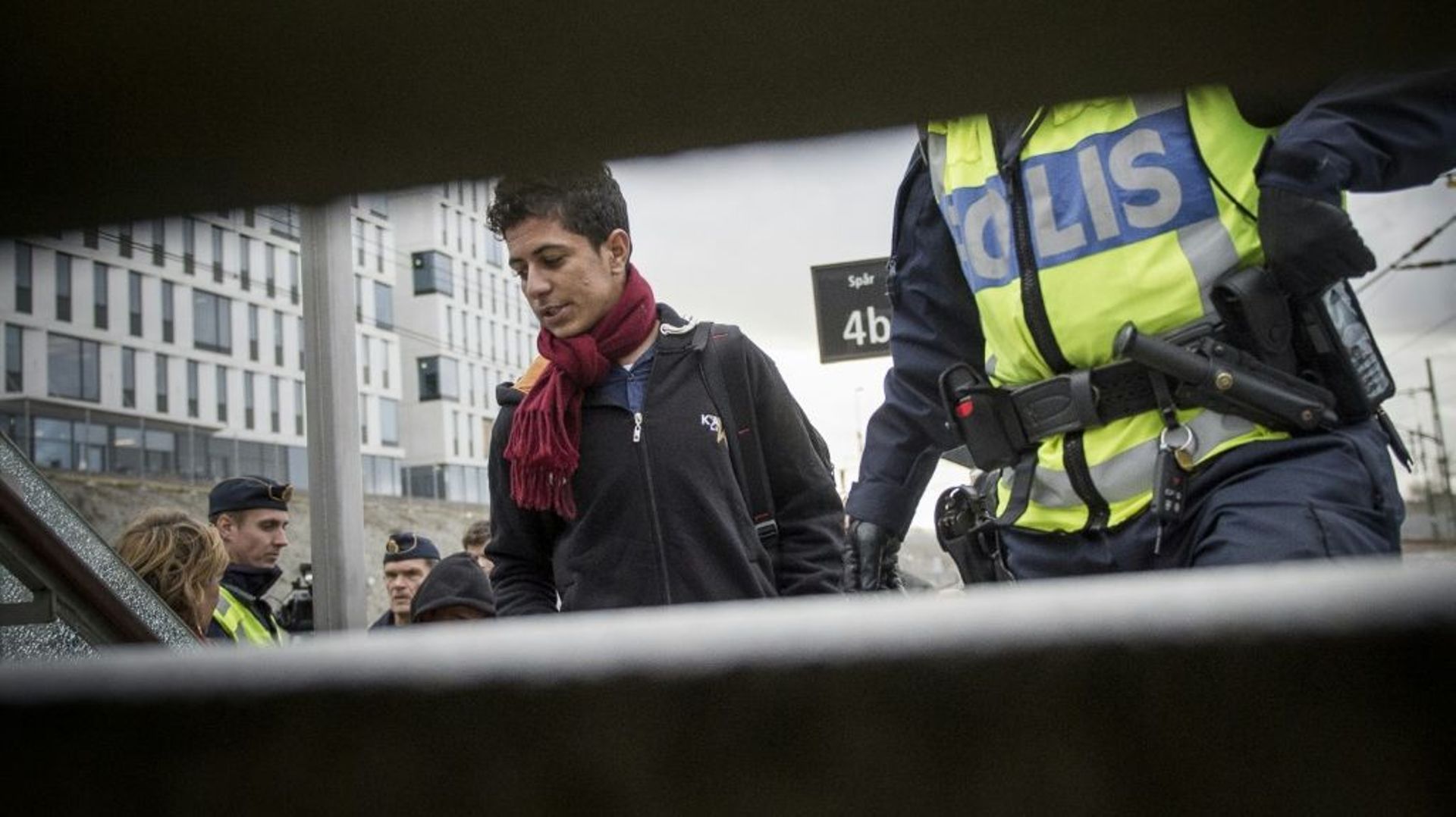 Un migrant est escorté par un policier suédois, dans une gare de Malmö, le 12 novembre 2015