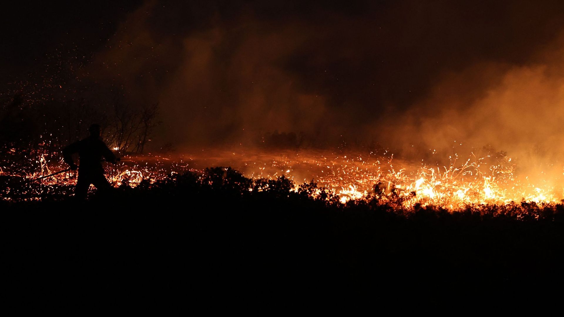 Un pompier travaille à l’extinction d’un feu de forêt dans l’agglomération de Drafi, au nord d’Athènes, le 19 juillet 2022.