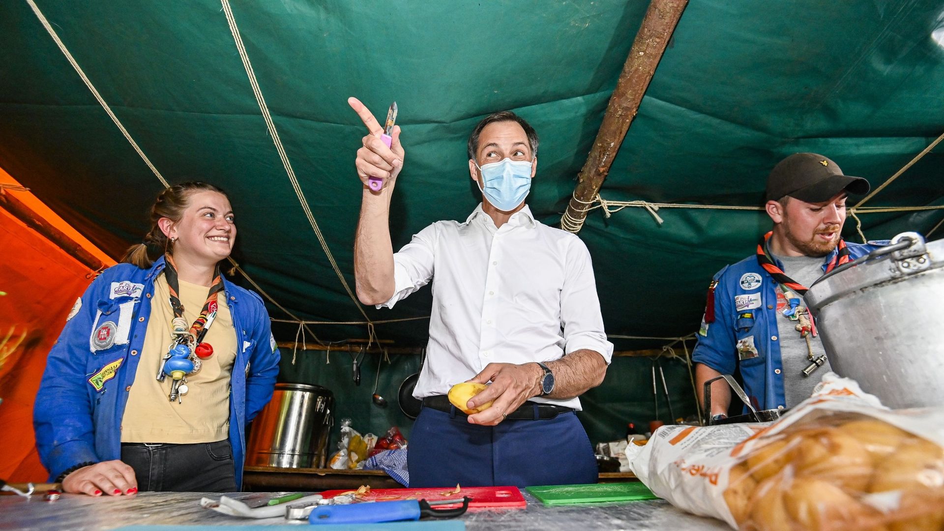 Le Premier ministre Alexander De Croo aide l'équipe de cuisine lors d'une visite d'un camp d'été des mouvements de jeunesse francophones à Faimes, mercredi 07 juillet 2021.