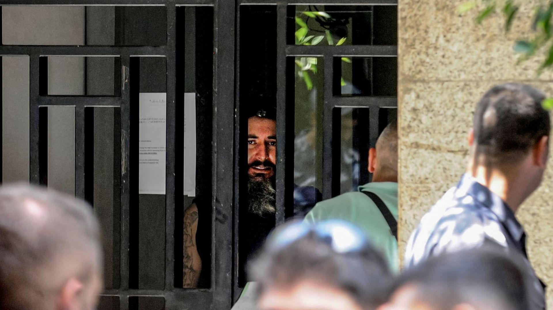 Un déposant armé s'adresse aux négociateurs derrière les barres de fer d'une banque locale à Beyrouth, après avoir pris d'assaut l'agence et pris en otage des employés et des clients. 