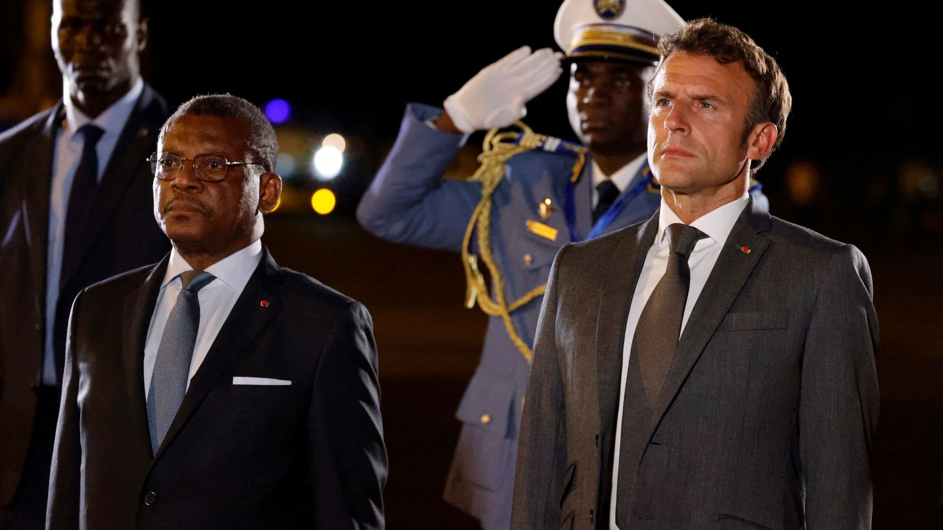 Français président Emmanuel Macron (à droite), flanqué du Premier ministre camerounais Joseph Dion Ngute (à gauche), regarde lors d’une cérémonie d’accueil à son arrivée à l’aéroport international Nsimalen de Yaoundé, le 25 juillet 2022. 
