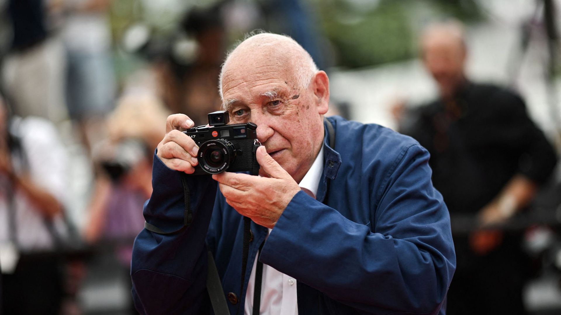 Le photographe français Raymond Depardon pose en tenant son appareil photo avant la projection du film "Holy Spider" lors de la 75e édition du Festival de Cannes à Cannes, dans le sud de la France, le 22 mai 2022. LOIC VENANCE / AFP